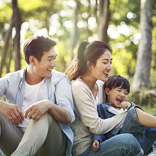 family with one child sitting outdoors